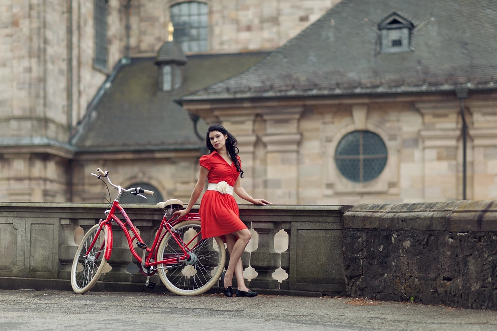 Natalie mit einem roten Fahrrad vor dem Fuldaer Dom