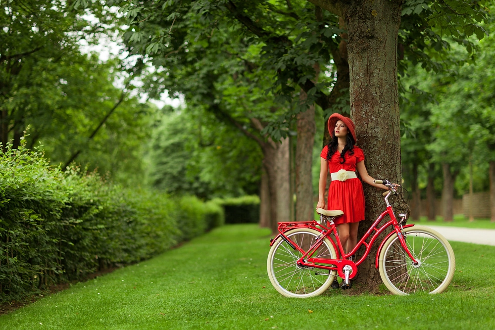 Natalie im Schlosspark, mit einem roten Fahrrad