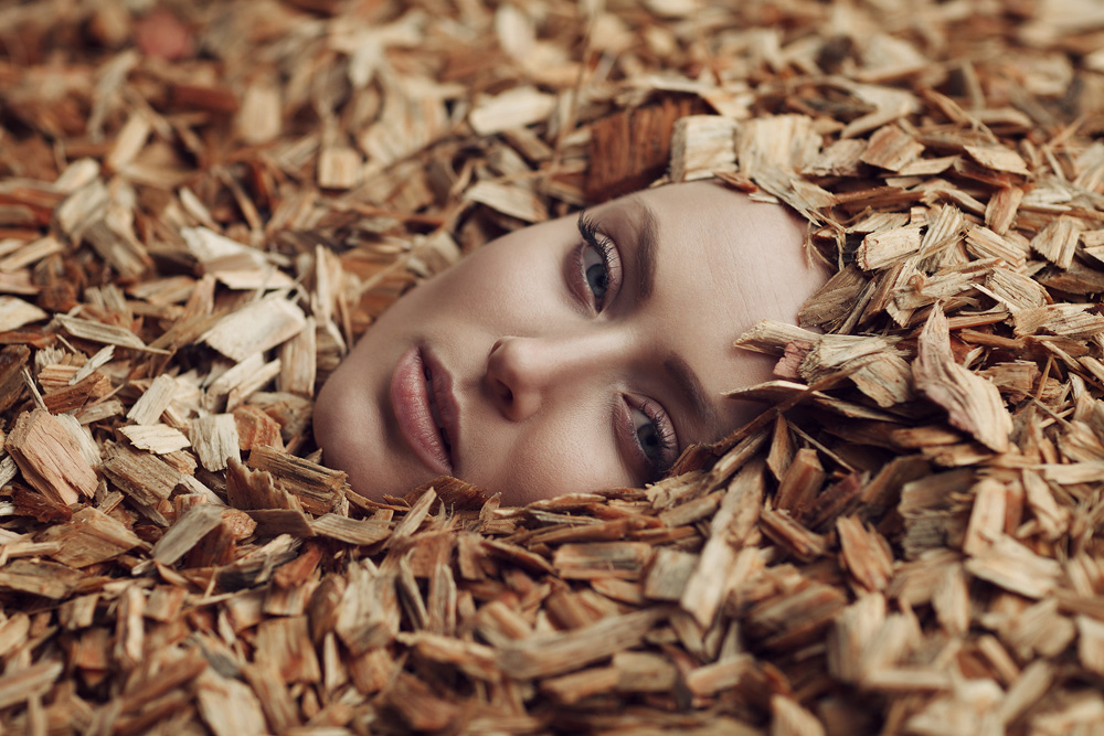 Portrait von Rebecca mit Rindenmulch um sie herum